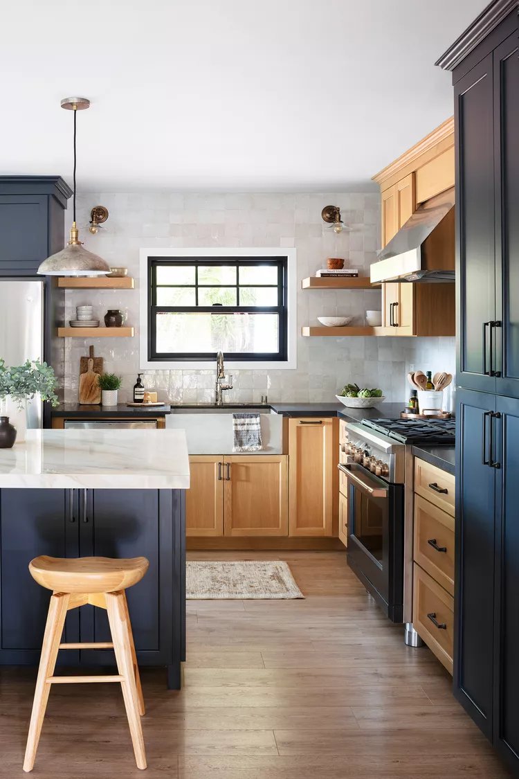 Modern remodeled kitchen with white cabinets, marble island, and pendant lighting